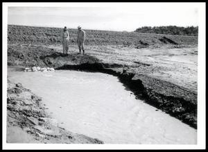 Primary view of object titled 'W. A. Bruce and C. W. Graham Observe Water Flowing From Drawdown Tube Below Site 2, Deep Creek'.