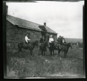 Stone out building with two men and two women riders