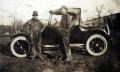 Photograph: Two oil field workers beside an automobile.