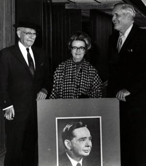 Ralph Evans with two people holding a portrait of Carl Albert.