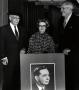 Photograph: Ralph Evans with two people holding a portrait of Carl Albert.