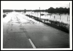 A UNIDENTIFED Flooded Road and Neighboring Field