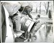 Photograph: Children from Longfellow Elementary Stocking Fish from a Barrel