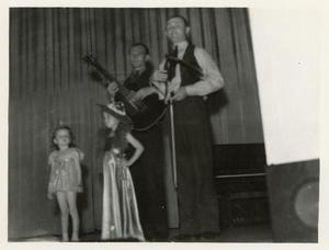 Two Girls on Stage with Two Men Playing Music