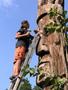 Photograph: Man Repairing Wooden Totem Pole