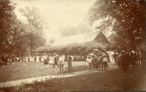 Men, women, children in front of a church or school.